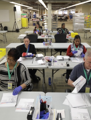 A room full of election workers processing ballots. 